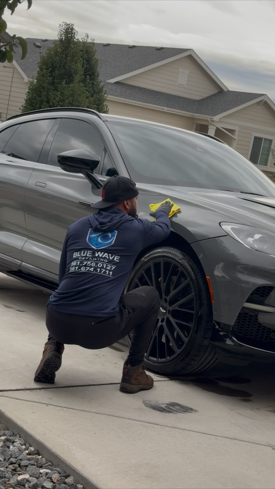 Blue Wave Detailing technician finishing a vehicle in a customer driveway