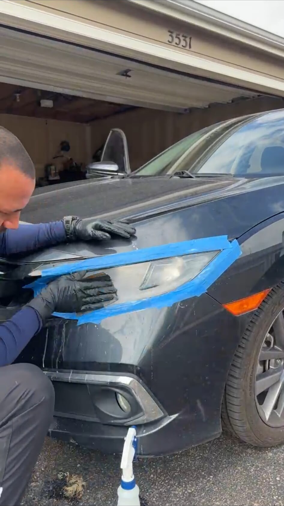 Technician restoring a headlight on a Honda Civic