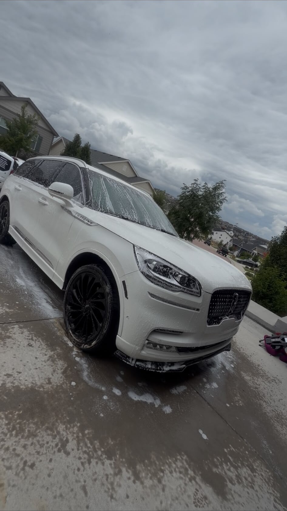 White Lincoln Aviator covered in foam in a driveway